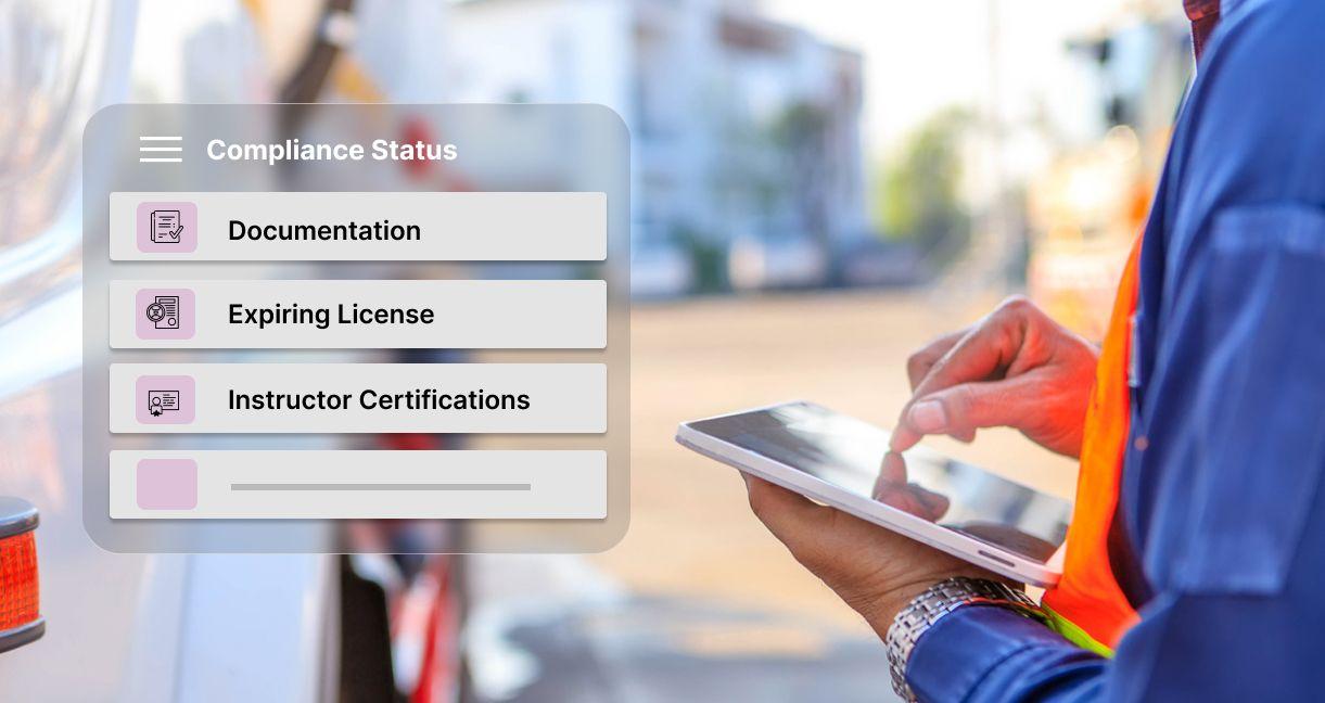 Driver using a tablet to manage compliance tasks through centralized driving centre management software, including licence tracking, instructor certifications, and documentation.